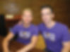 Dan Savage with his hand on his husband Terry's shoulder, both wearing It Gets Better Project T-shirts