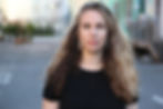 Filmmaker Kate Hackett, with long hair and long earrings, in a Los Angeles street