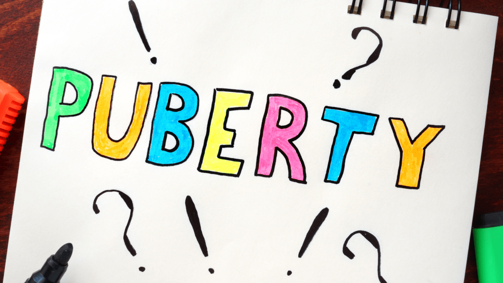 puberty written on a pad of paper in multiple colors, surrounded by exclamation and question marks